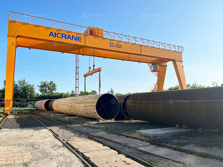 Heavy duty gantry crane handling steel pipes in an outdoor steel storage yard