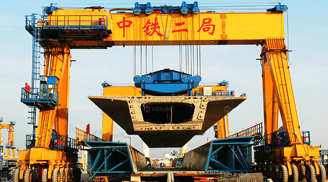 RTG crane handling long-span precast bridge girders in a precast yard
