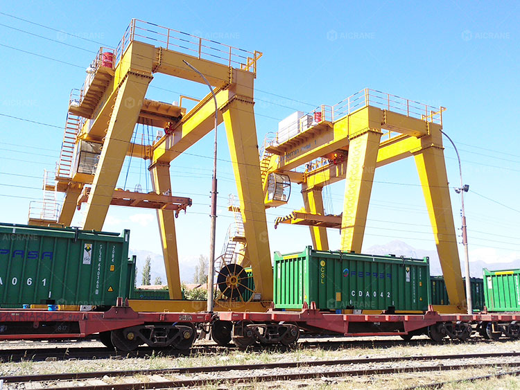large gantry cranes loading heavy containers in a railway freight yard
