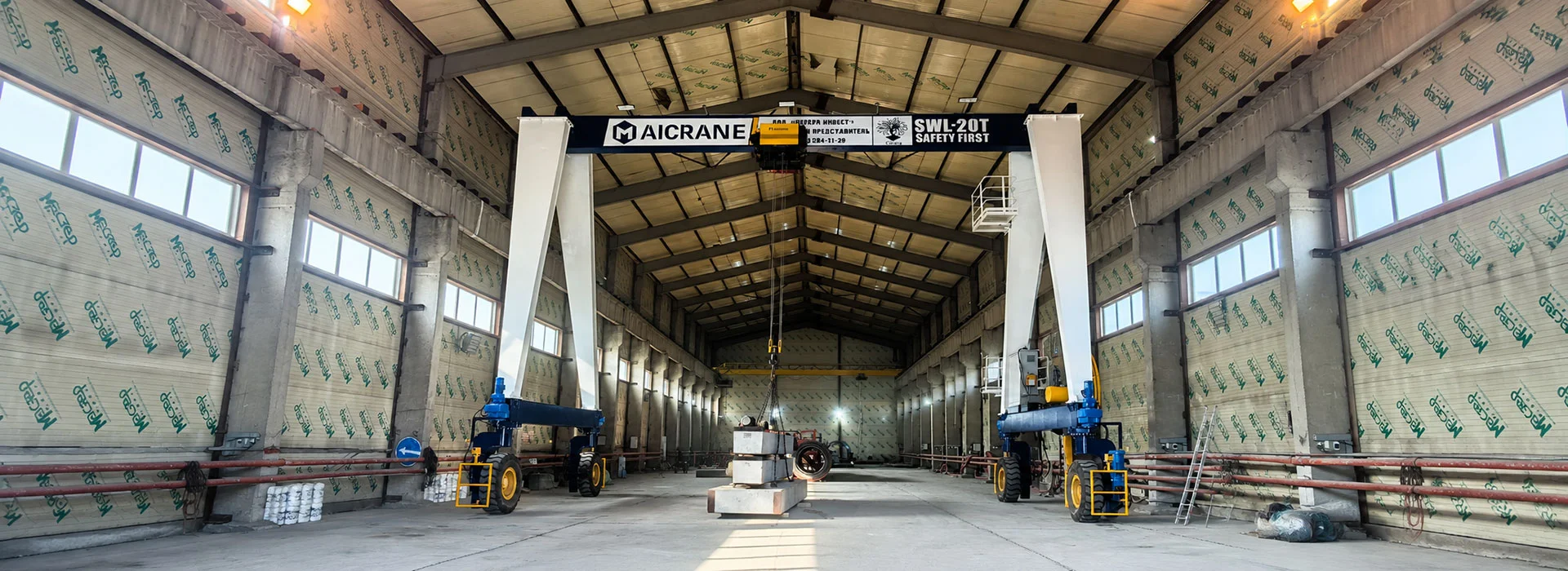 Indoor rubber tyred gantry crane operating in a manufacturing workshop