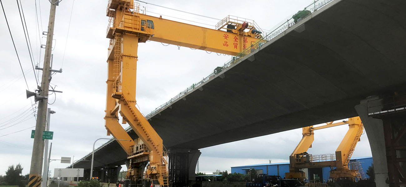 RTG crane positioning a massive precast concrete girder at a viaduct construction site