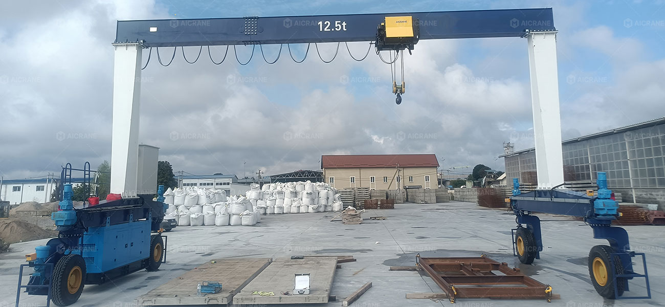 rubber tyred gantry crane lifting precast concrete beam in an industrial yard