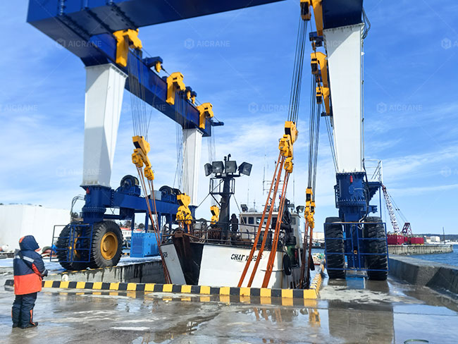 Shipyard boat hoist lifting a vessel in coastal marine environment