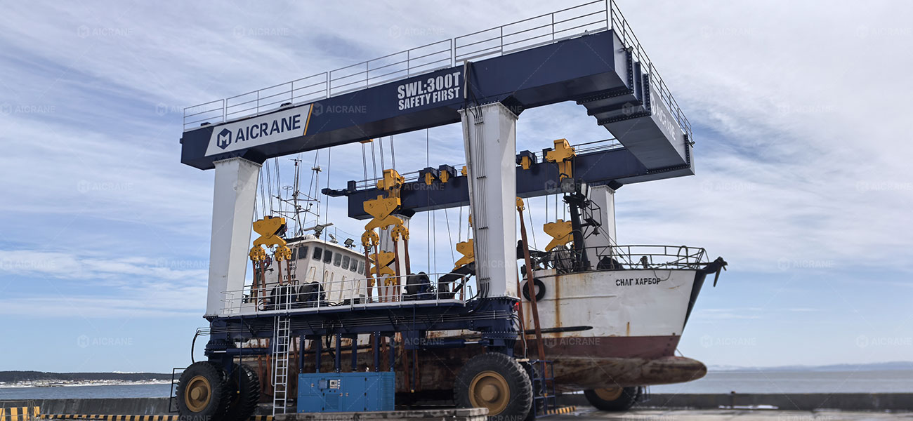 rubber tyred crane lifting a vessel in a shipyard marine environment