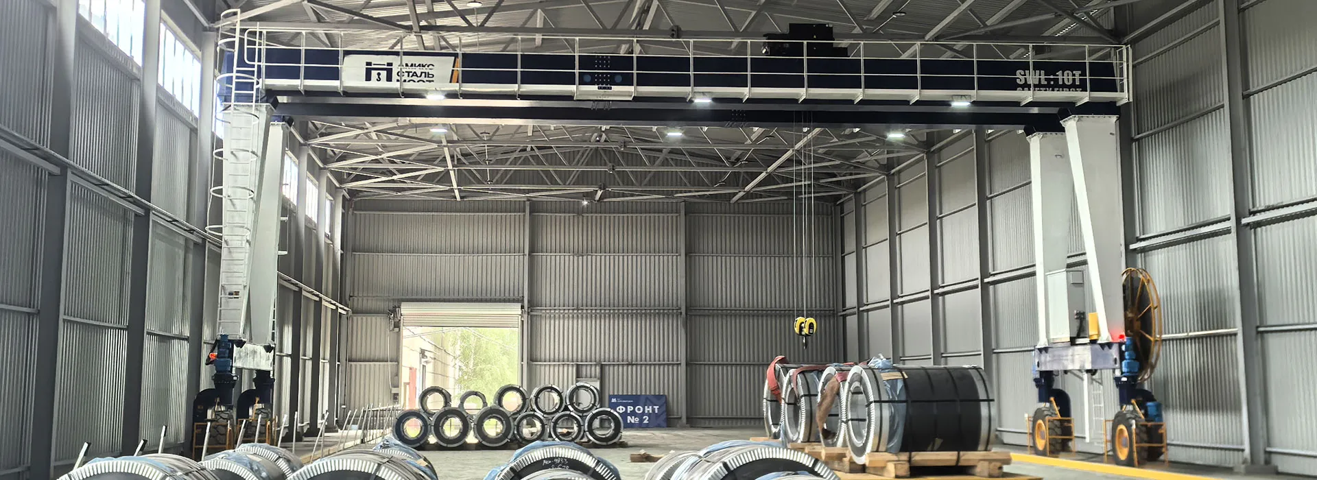 Cable reel electric RTG crane handling steel coils in indoor facility for eco-friendly yard operations
