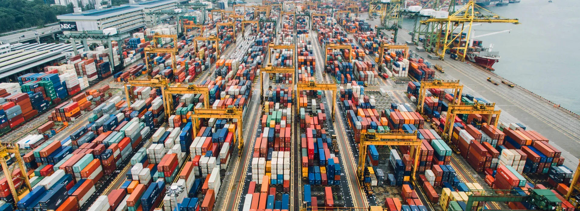 Container terminal yard with stacked containers and handling equipment supporting efficient container flow