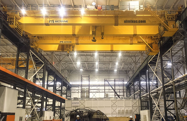 Heavy duty double girder overhead crane handling heavy components in an industrial workshop