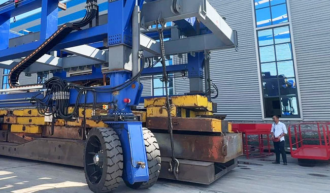 Operator using wireless remote control to operate a straddle carrier during material handling operations