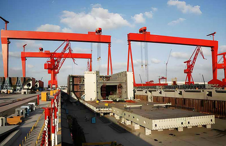 Shipyard gantry crane handling hull blocks and steel structures in a shipbuilding yard