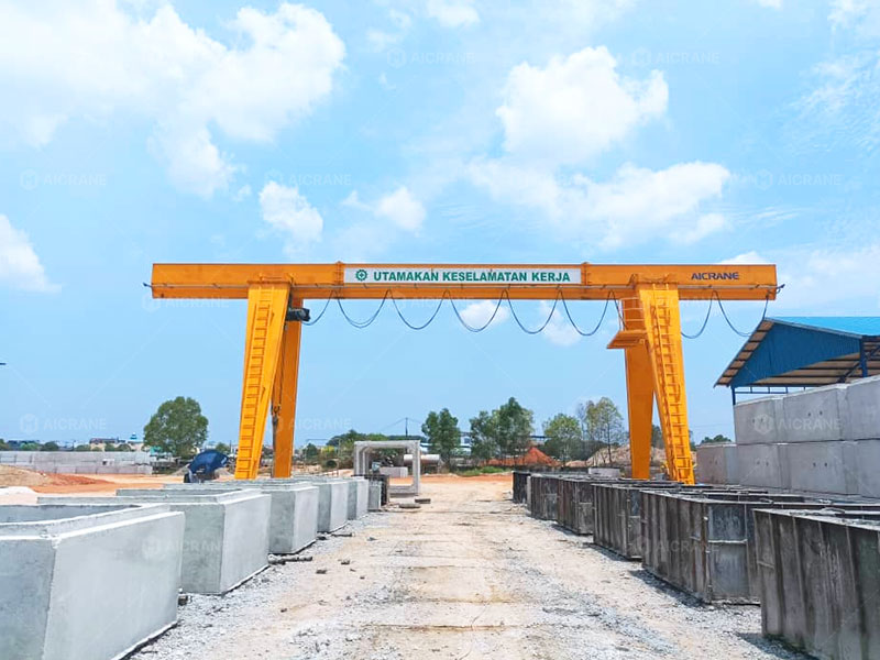 Single girder gantry crane transferring precast concrete products between storage and loading areas in Indonesia