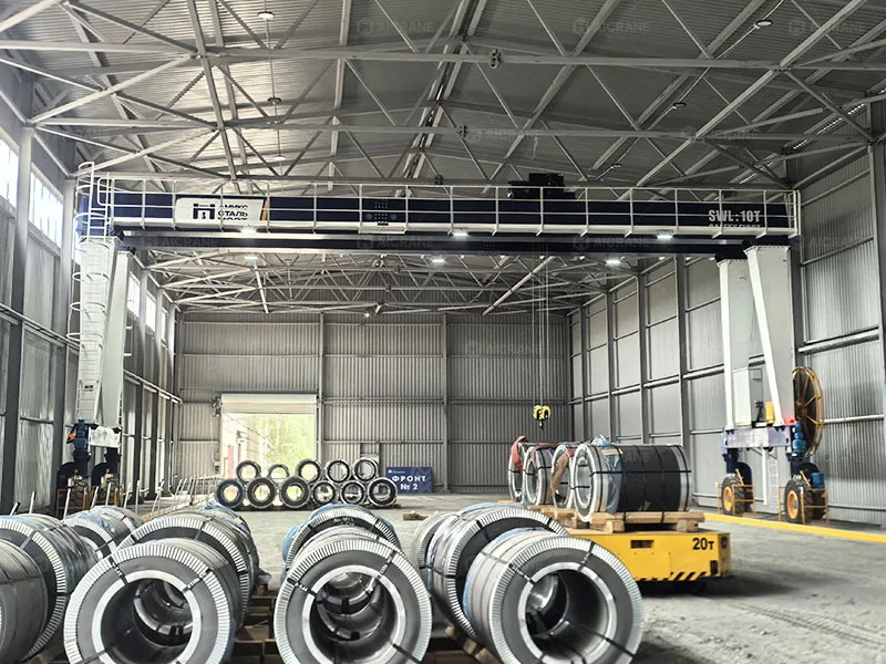 Cable reel electric RTG crane handling steel coils in indoor facility for eco-friendly yard operations