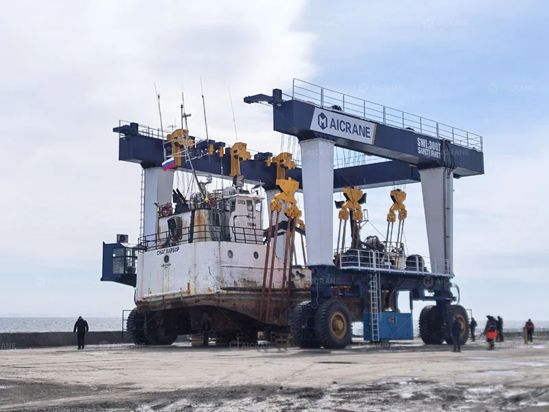 Boat travel lift handling a fishing boat in a shipyard